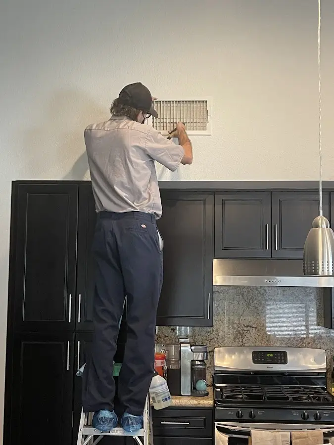 Technician inspecting an air vent during HVAC service in Dublin
